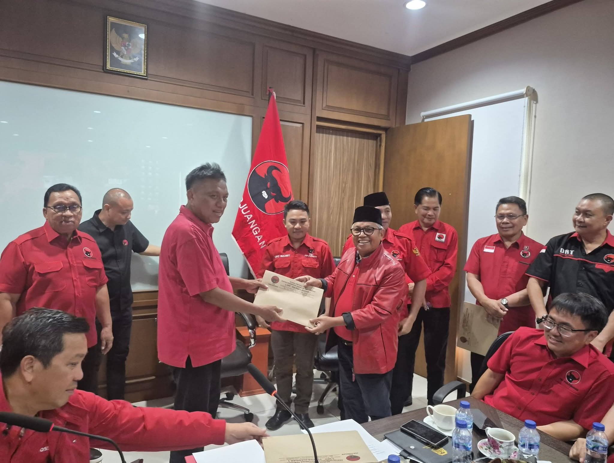Terlihat ketua DPD Partai Demokrasi Indonesia Perjuangan (PDIP) Sulut Prof. Dr. (H.C) Olly Dondokambey, SE. saat menyerahkan pengesahan dan penetapan pimpinan DPRD Kabupaten Bolaang Mongondow Utara kepada ketua DPC PDI Perjuangan Drs. H. Amin Lasena dan di dampingi sekertaris DPC PDI Perjuangan Safrizal Walahe, SH. MH. (doc. Istimewa)